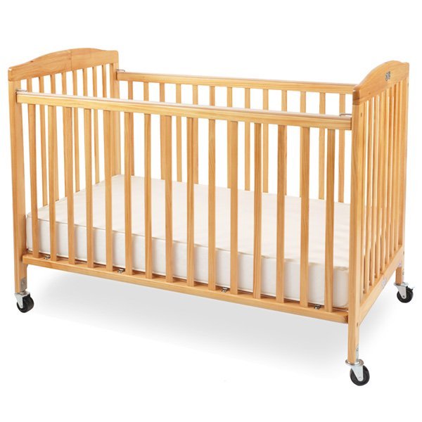 A wooden baby crib with casters, featuring vertical slats and a white mattress.