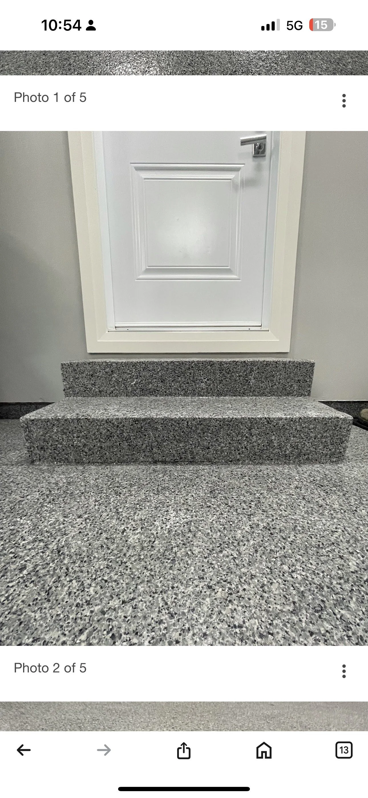 A small set of gray speckled granite stairs leading to a closed white door with a silver handle.