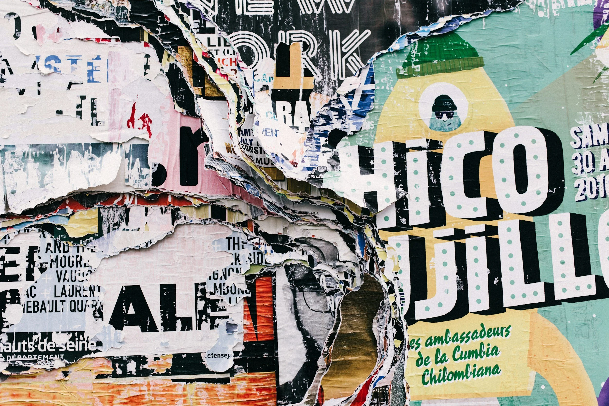 Affiches déchirées et superposées avec des textes et des images,colorees en noir, blanc, vert, jaune, rose, bleu et violet.