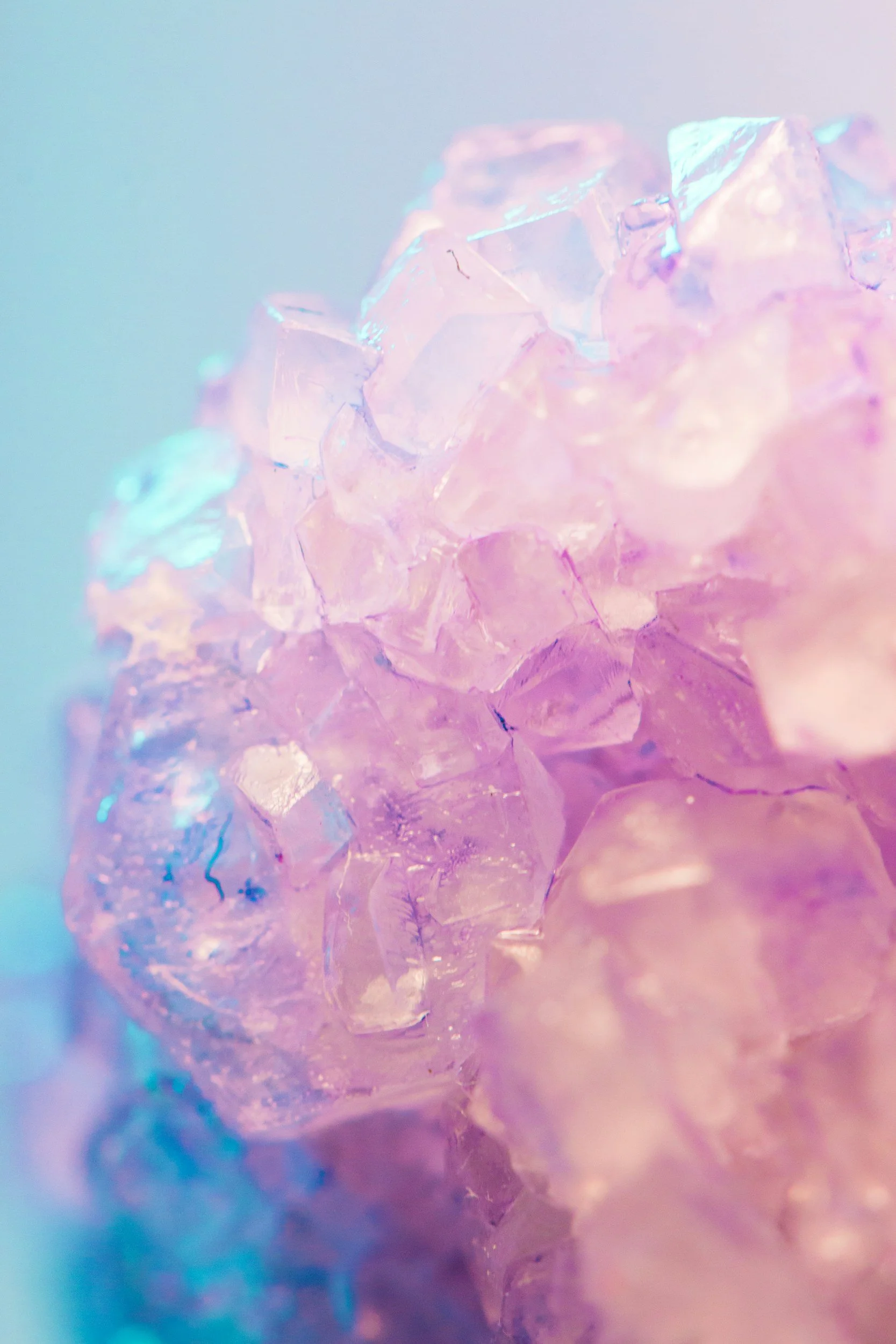 Gros plan de cristaux d'iridescence rose et bleu avec effets lumineux doux.