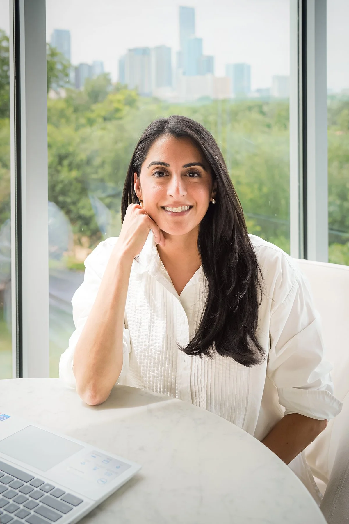 Amrtia, based in Austin, smiling, wearing a white blouse