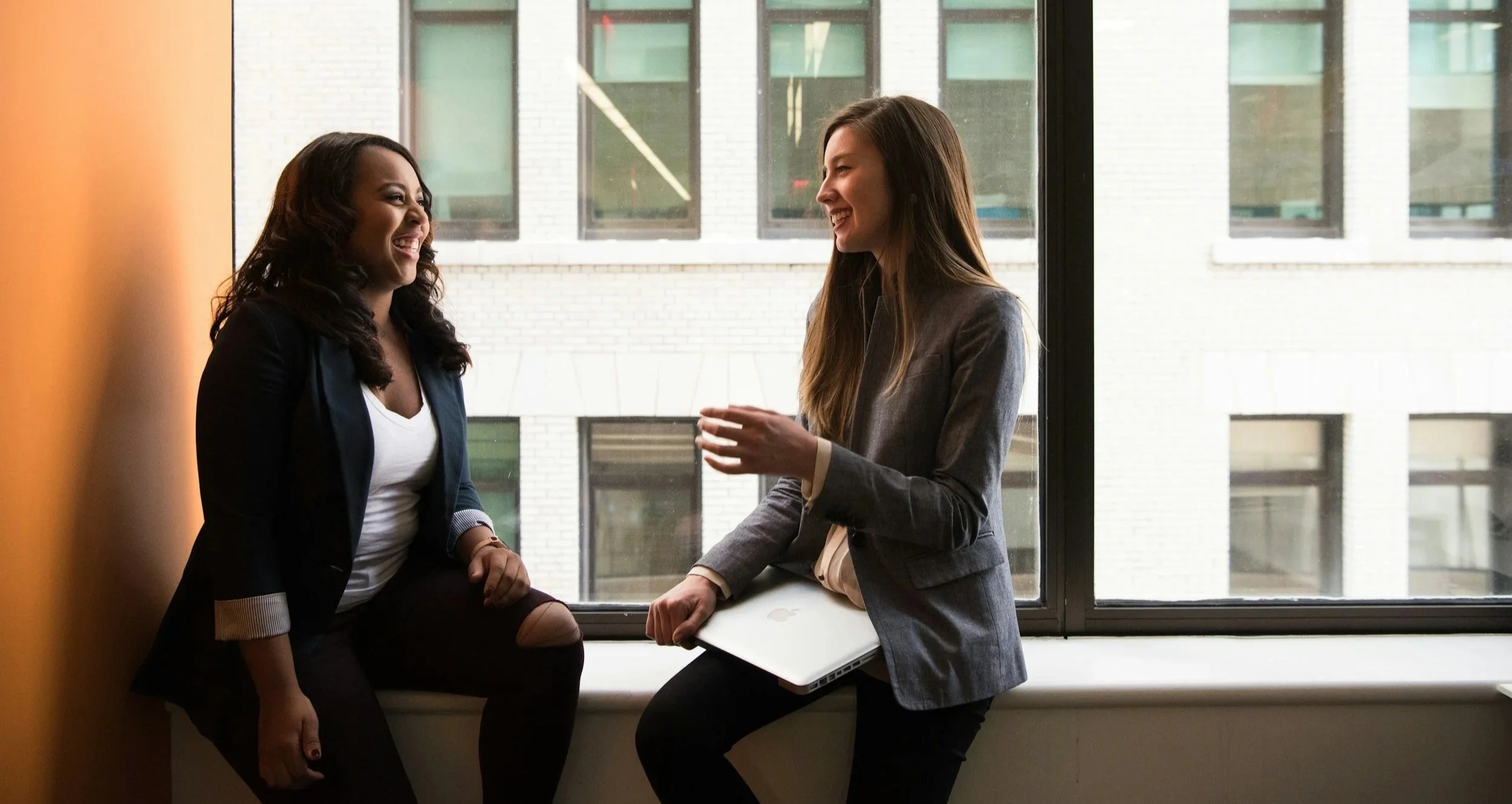 Two women in blazers, talking in Austin