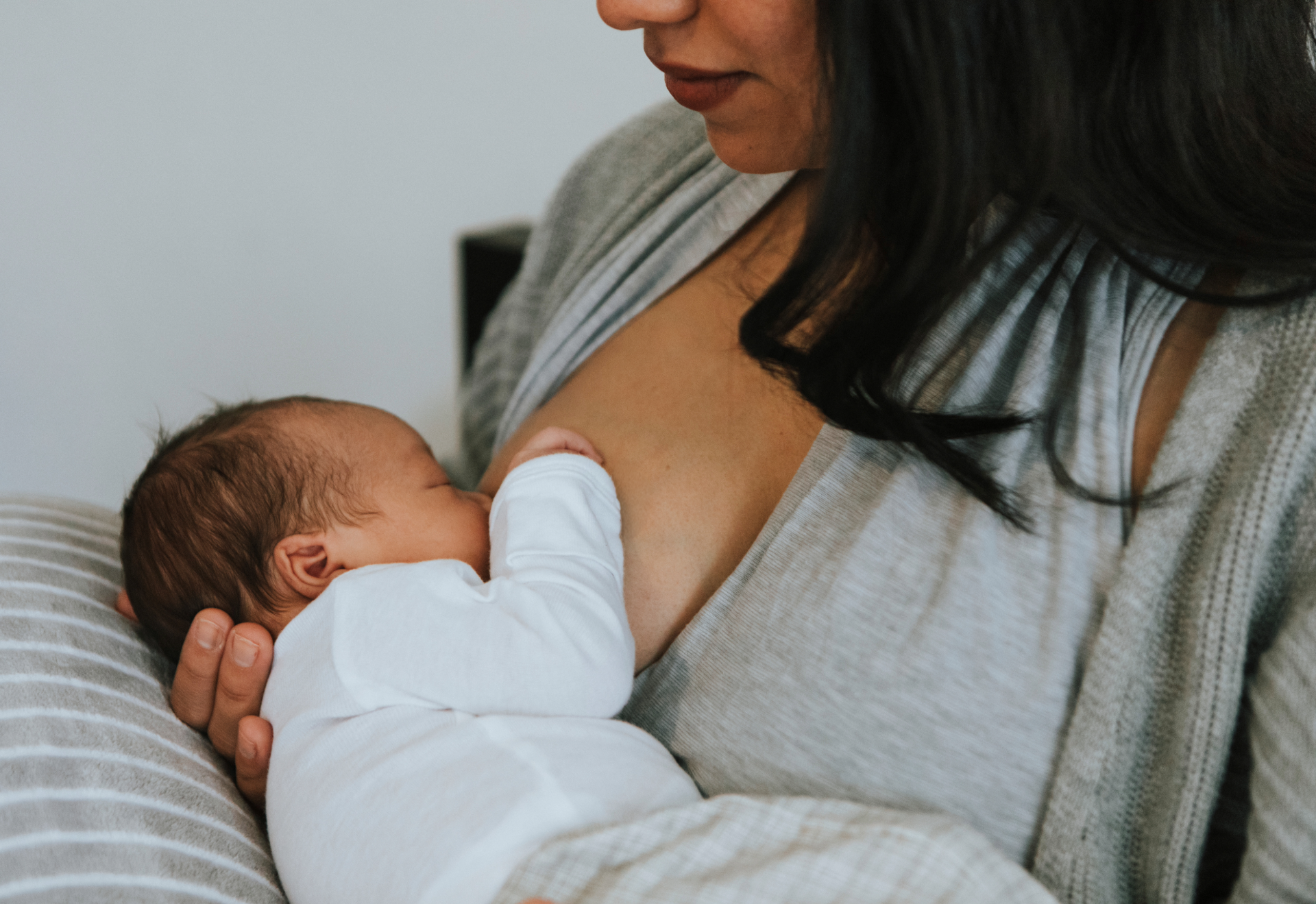 A woman breastfeeding a newborn baby.