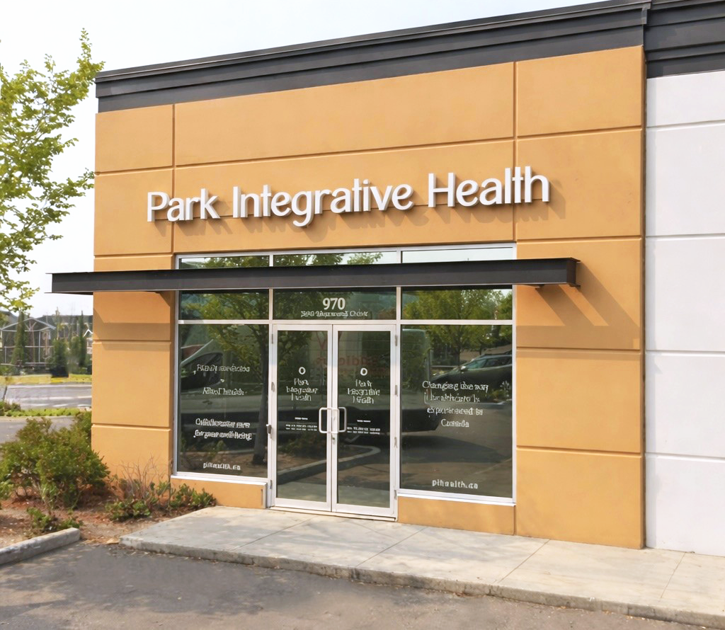 Exterior view of a healthcare facility named Park Integrative Health with glass doors and windows, located at 970, with a beige and white facade and some trees in the background.