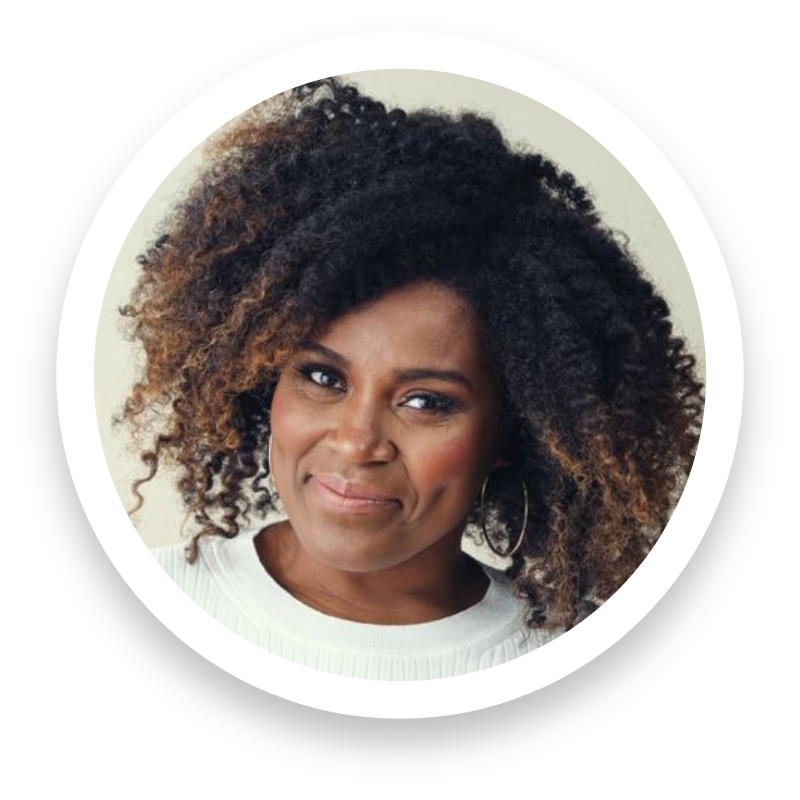 Close-up of a woman with curly, voluminous hair, wearing a white top and hoop earrings, smiling slightly.