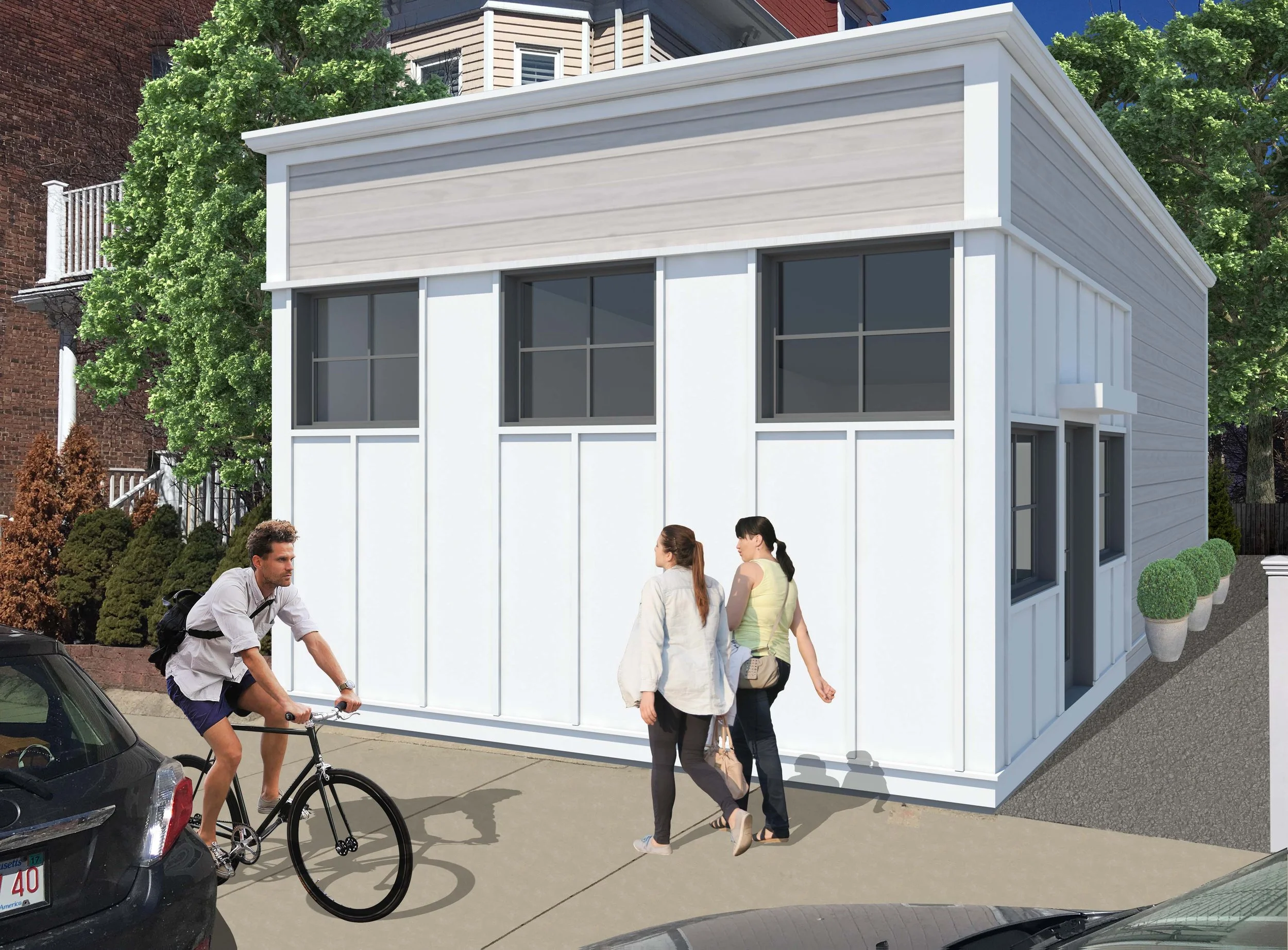 A modern, white residential building with large windows, surrounded by greenery, and three people on the sidewalk in front of it, including a cyclist and two women.