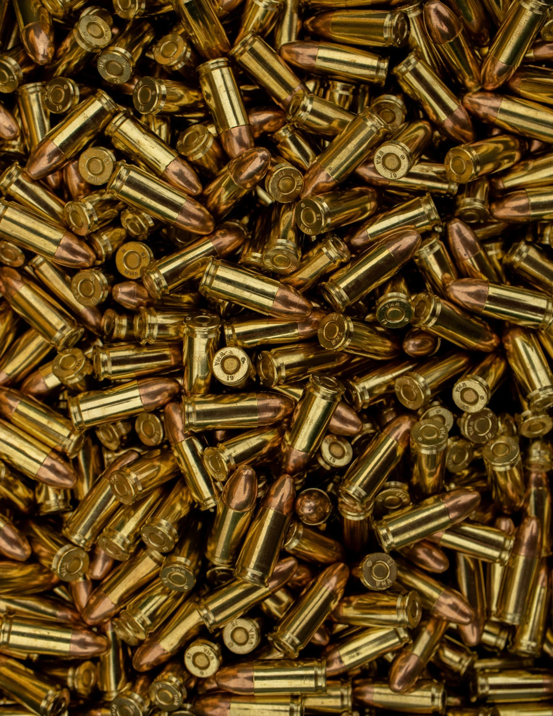 A large pile of brass cartridges with copper-colored bullets.