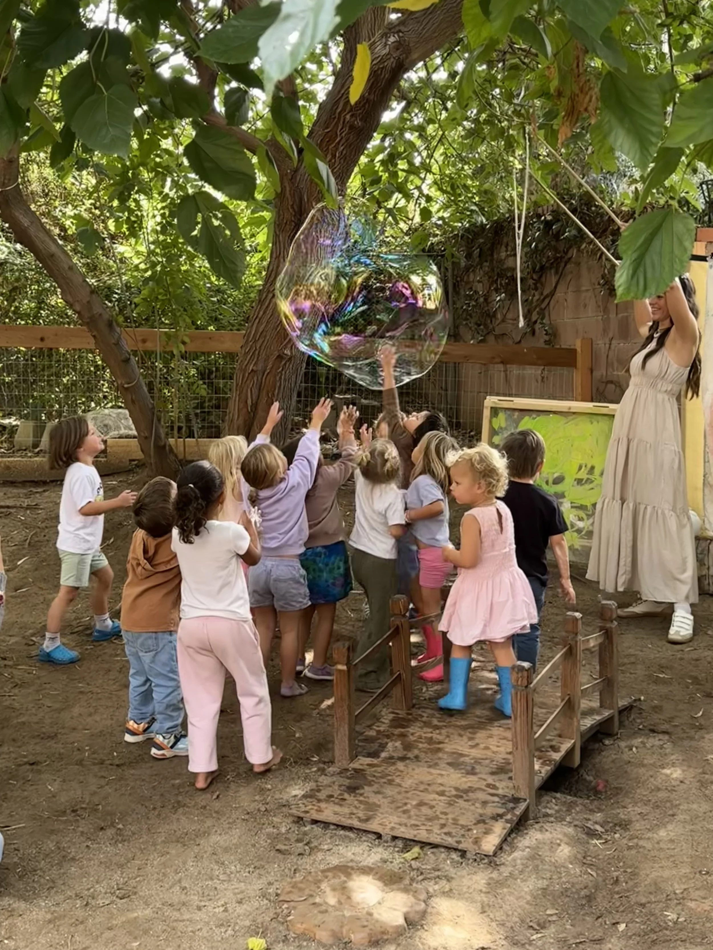 Little Folk House Children Playing With Giant Bubble Outdoors