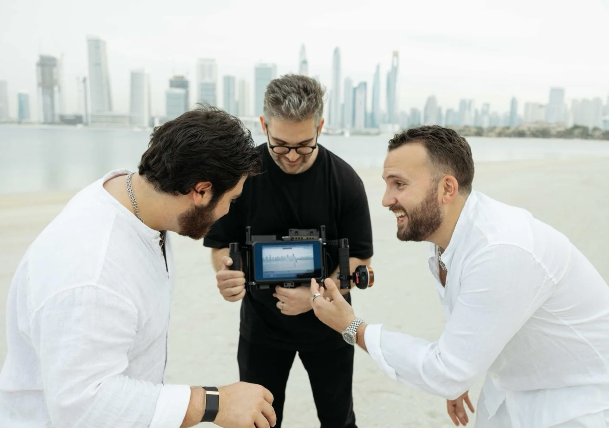 Three men reviewing footage on a camera outdoors with a Dubai skyline in the background. My parents are divorced, and Nawsir music video by Kynda Creative.
Pedram Farjam.