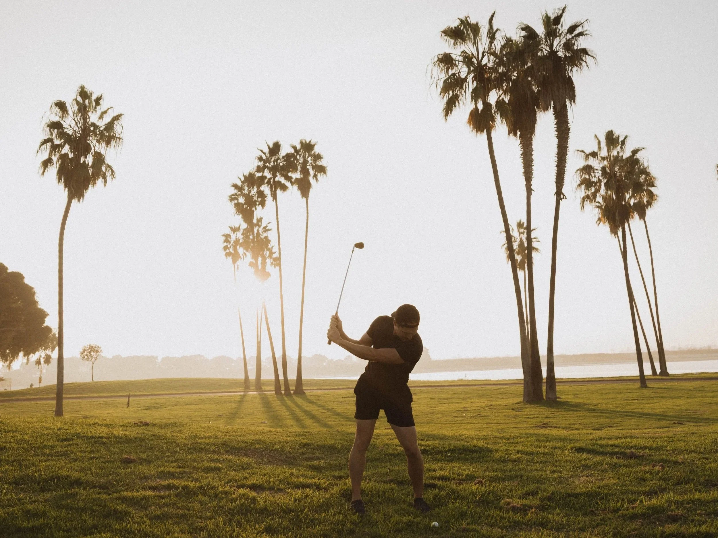 elite golf mechanics training iron shot at sunset