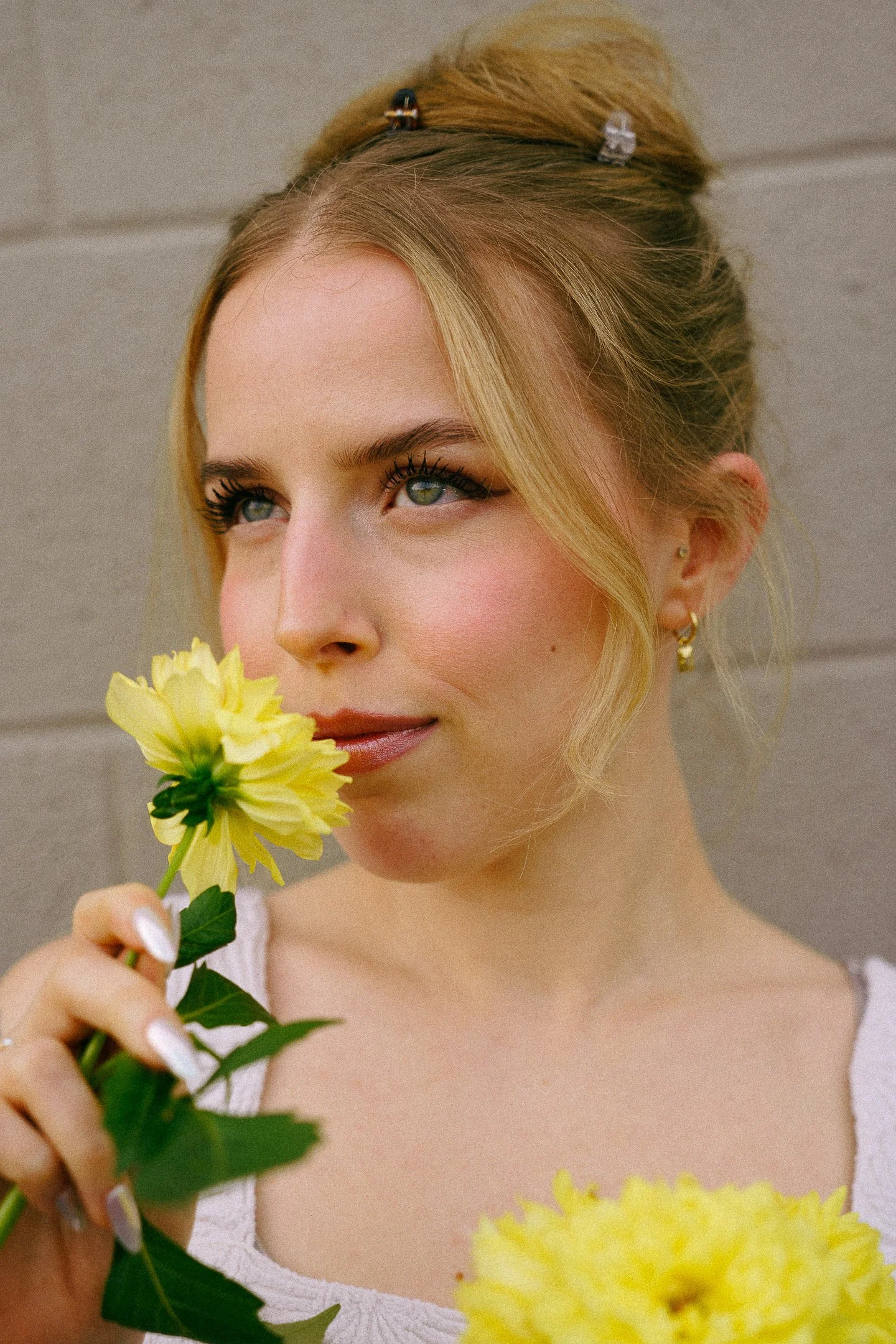 Emma Salazar, Advanced Esthetician at Dahlia Beauty Bar (best day spa in Toledo, Whitehouse, Waterville, Perrysburg, Maumee) holding lemons as plant-based skincare and wellness are a big focus at Dahlia Beauty Bar.