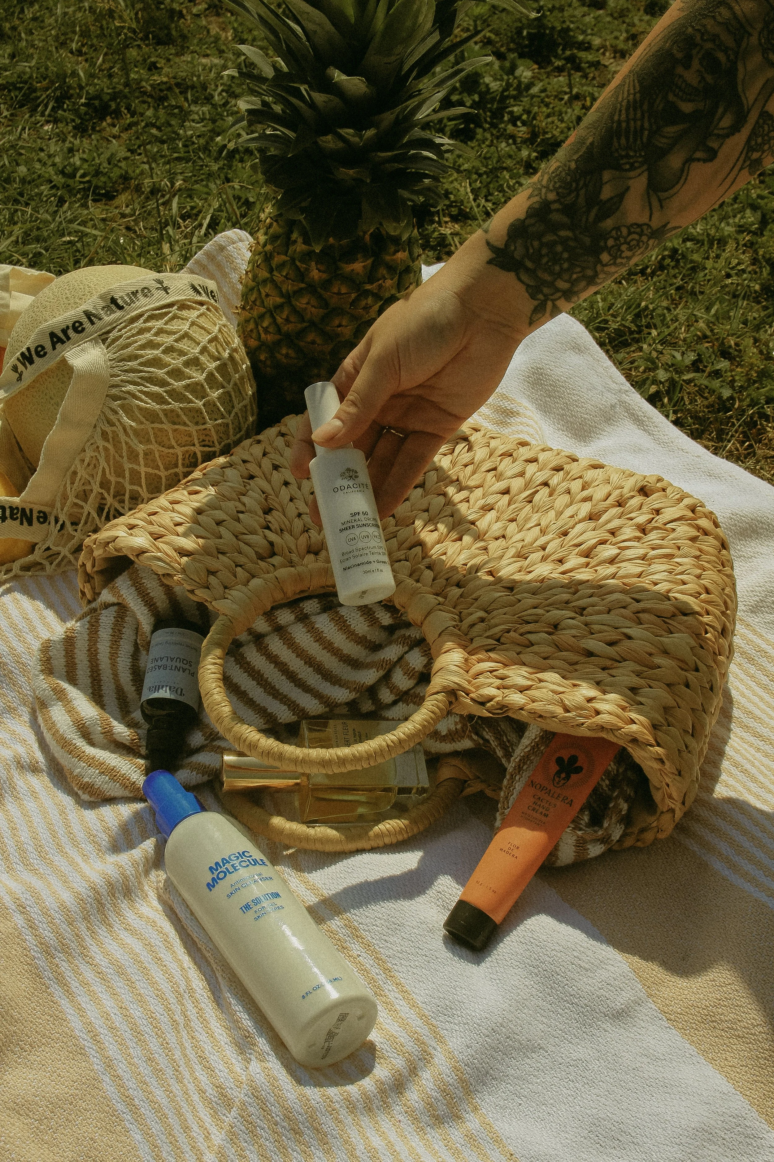 Summer beach basket of natural, plant-based skincare at Dahlia Beauty Bar featuring our best-selling facial oils, sunscreen, natural fragrance, and more