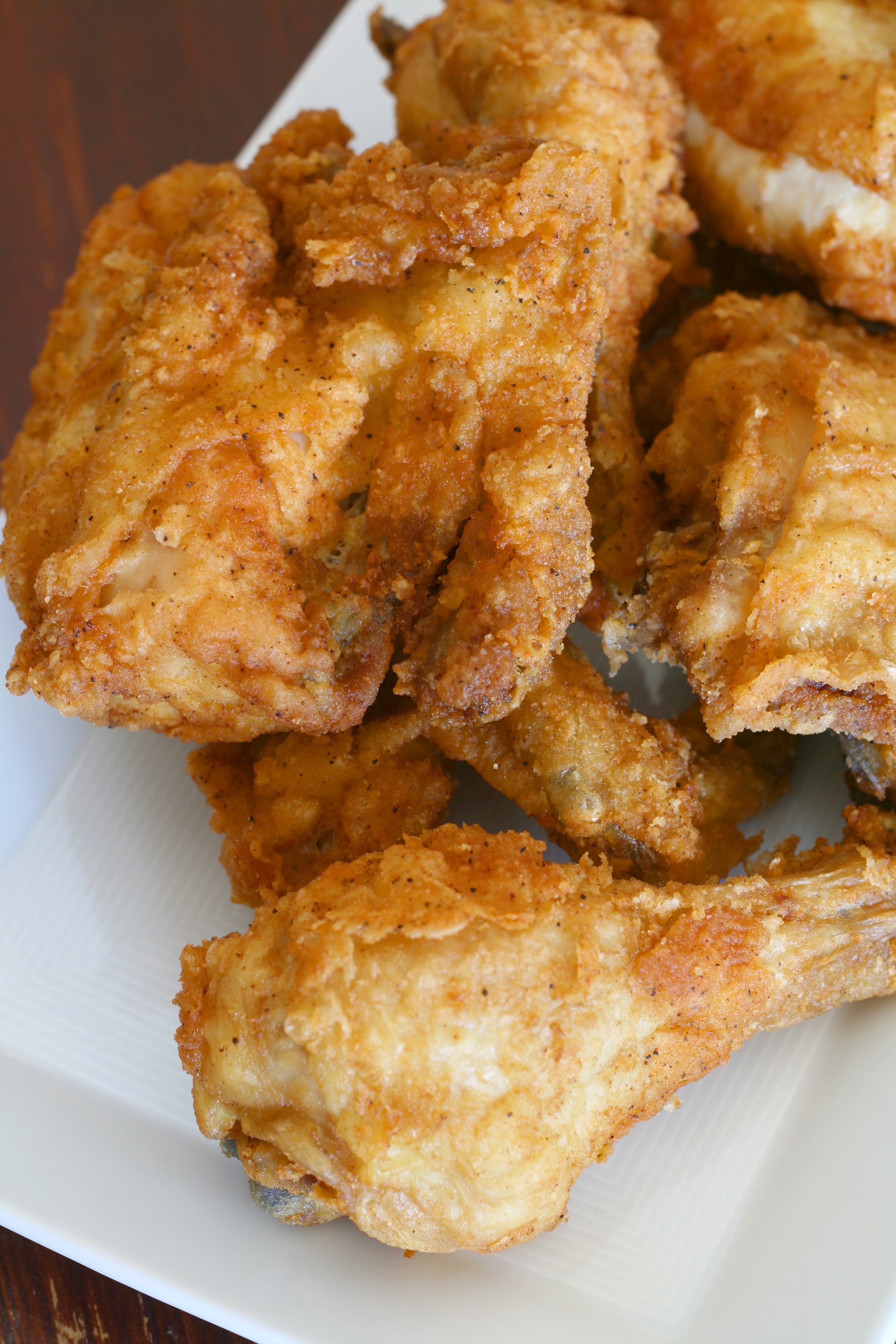 Close-up of fried chicken pieces on a white plate.