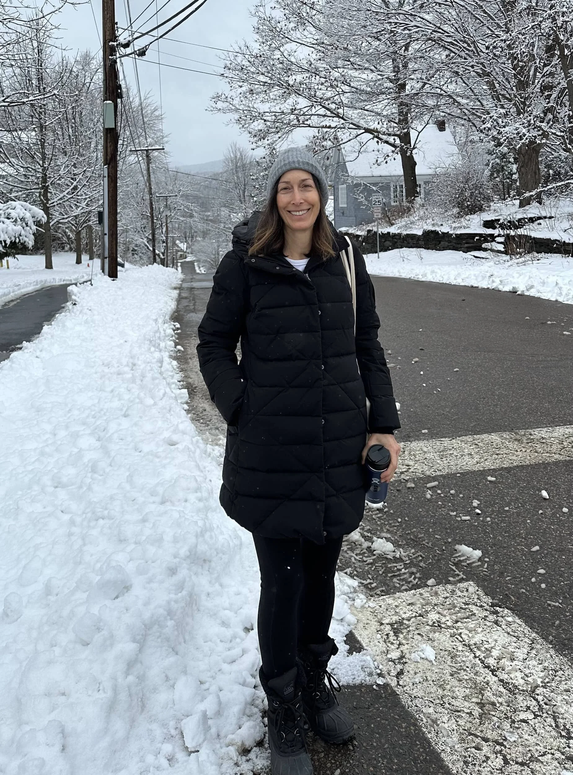 Jean Grabow smiling, in black winter jacket with snowy background