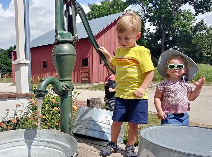 kids at the water pump in Shawnee Town
