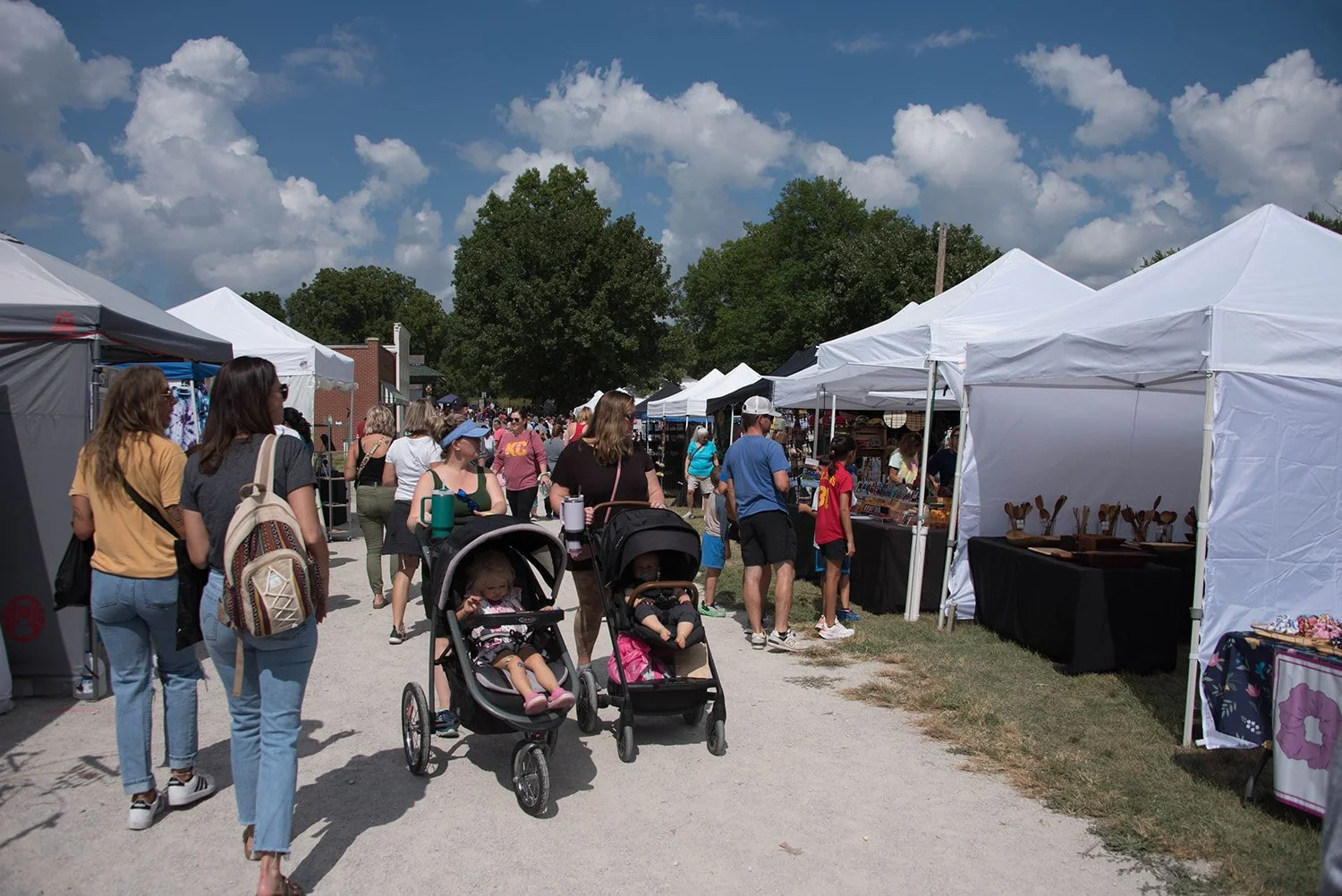 moms push strollers through the craft fair
