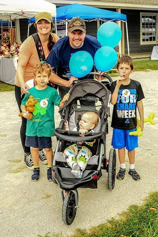 A family  with balloons enjoys Shawnee Town