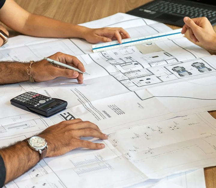 building plans with hands of people working on them