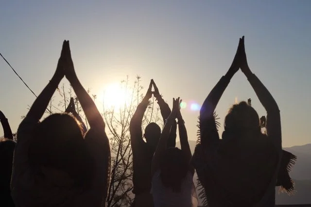 people practicing yoga at sunrise