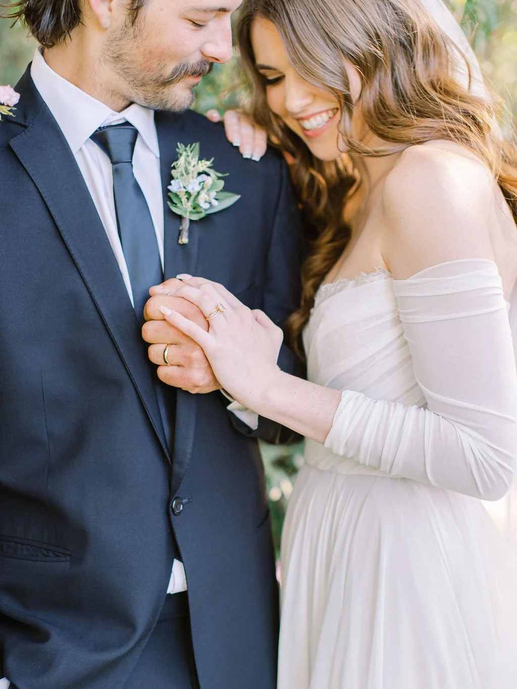 Bride with soft, radiant bridal makeup sharing an intimate moment with her partner, looking confident and effortlessly beautiful