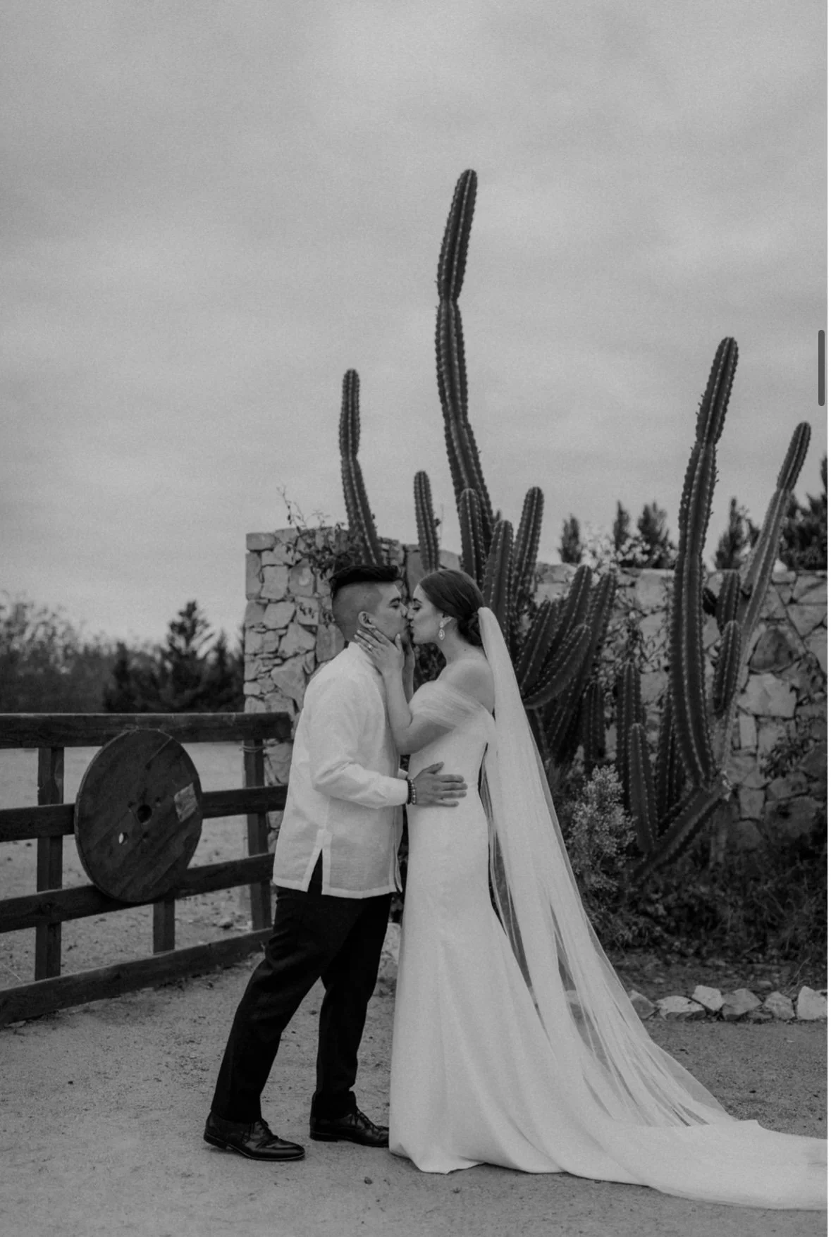 Bride with classic, timeless bridal makeup sharing a romantic kiss with her partner in an editorial-style black and white moment