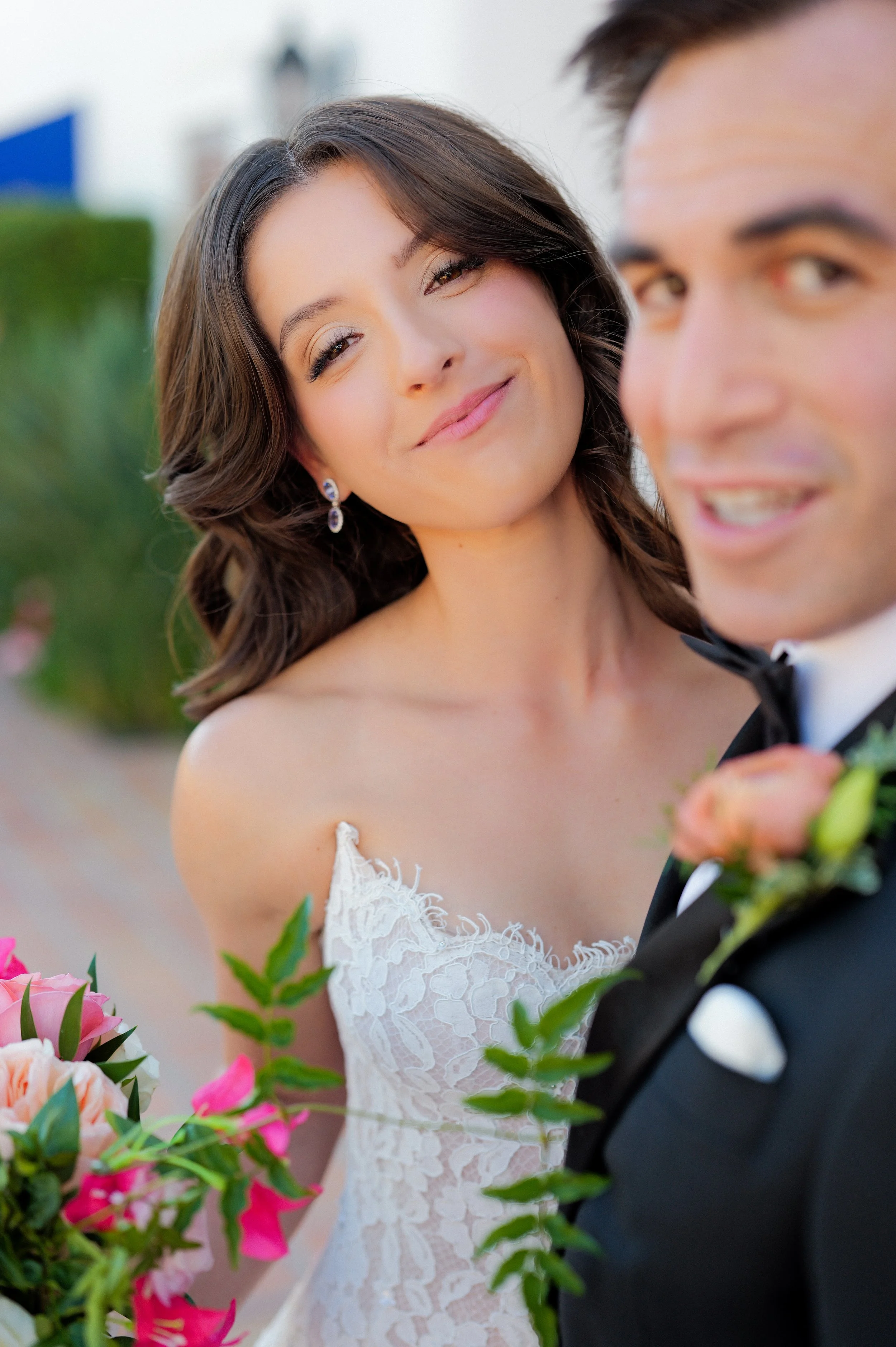 Bride with flawless, long-lasting wedding makeup smiling confidently with her partner during golden hour portraits