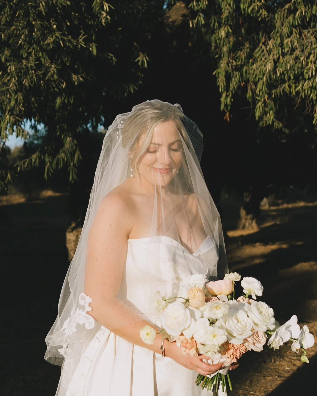 Bride with soft, glowing bridal makeup holding her bouquet, looking calm, confident, and effortlessly radiant in natural light