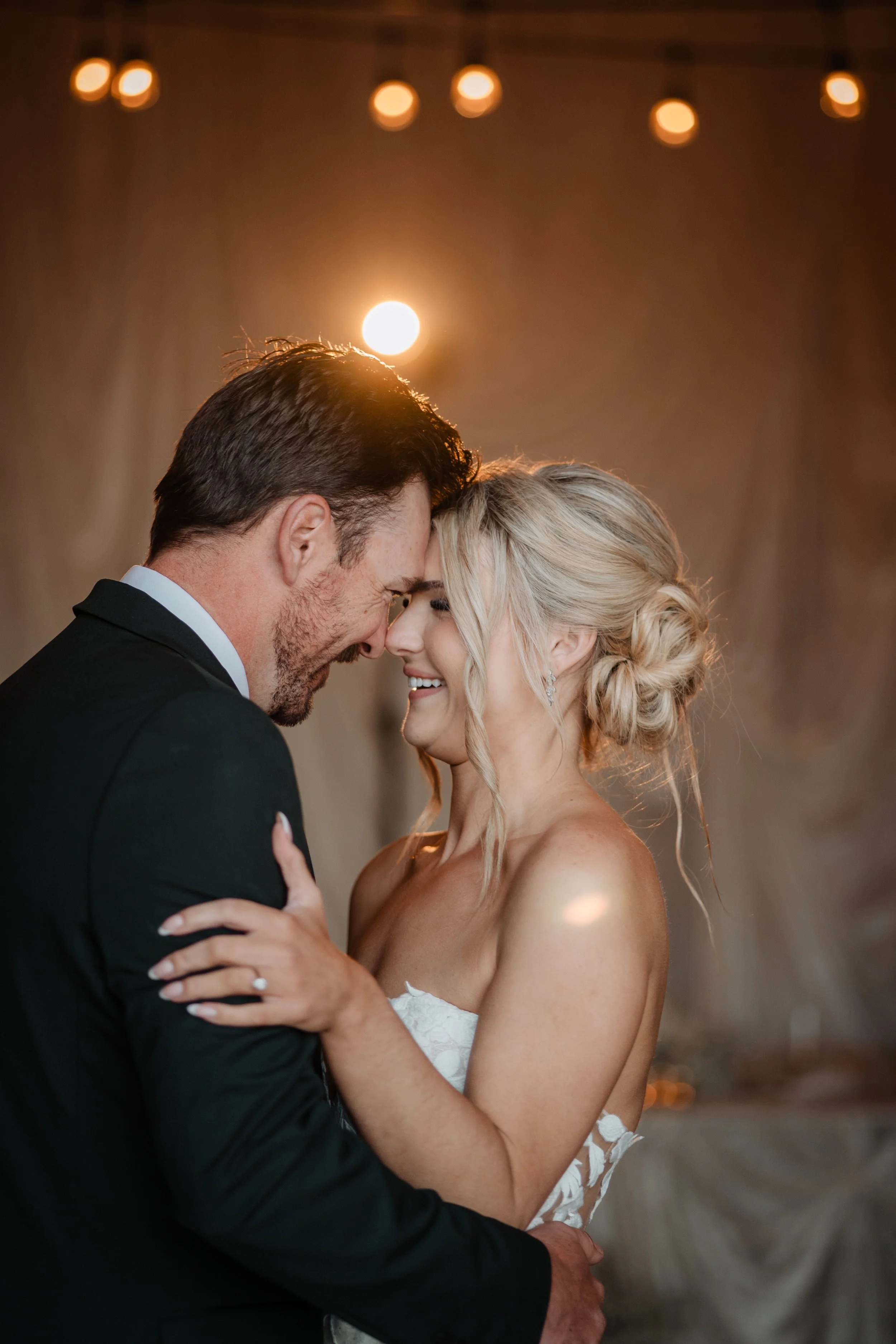 Bride with glowing, long-lasting wedding makeup sharing an intimate moment with her partner, looking radiant and camera-ready