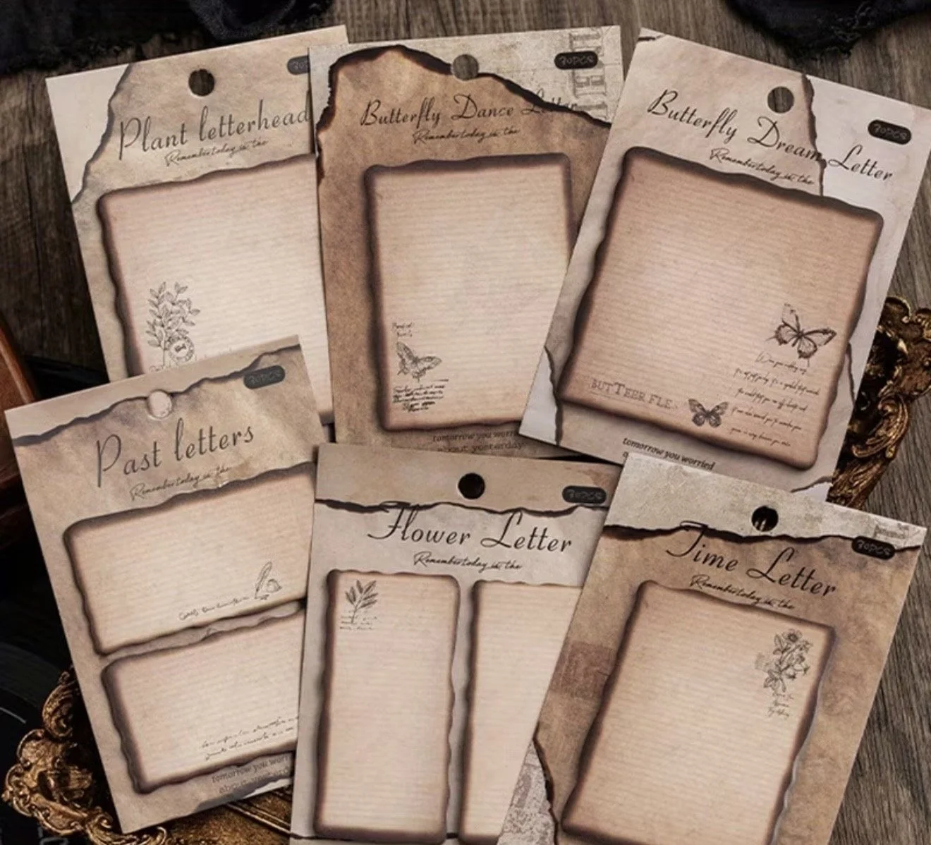 Collection of decorative paper sheets with vintage-style burnt edges, each labeled for different types of letters: Plant letterhead, Butterfly Dance, Butterfly Dream, Past letters, Flower Letter, Time Letter. Each sheet features small illustrations a