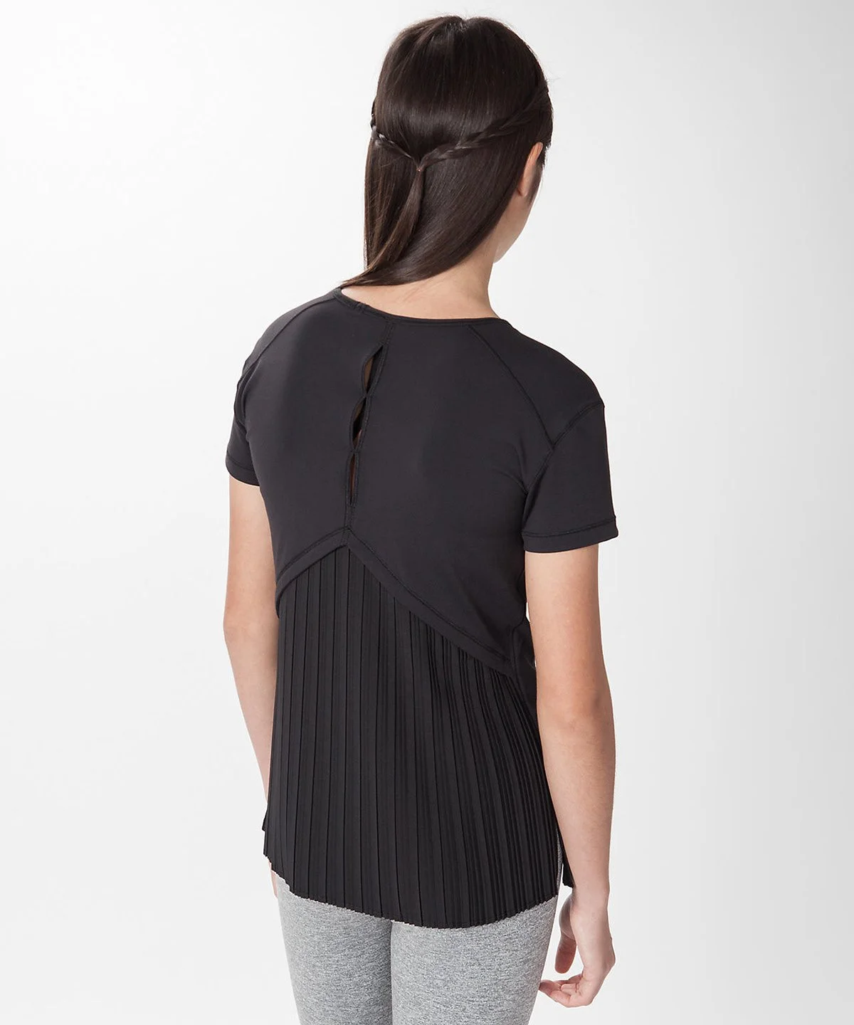 Rear view of a woman wearing a black shirt with a pleated and cutout design on the back, standing against a plain white background.