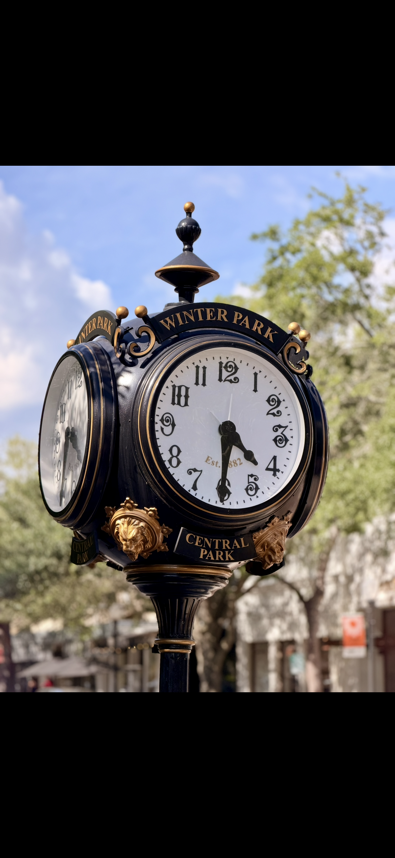 Vintage street clock with black and gold detailing, displaying the time as 4:29, located in Central Park, New York City.