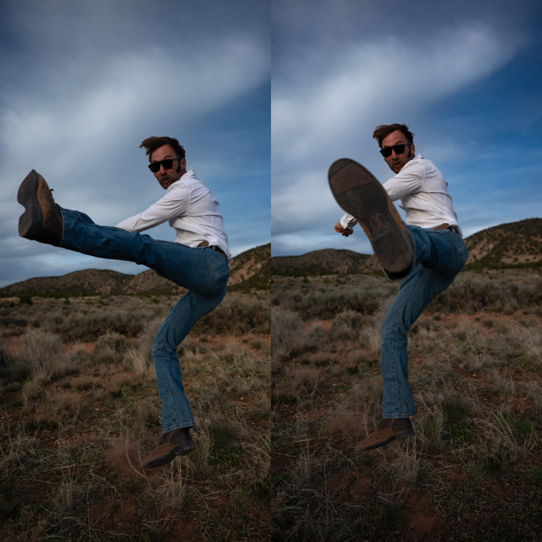Man in sunglasses and white shirt kicking in a desert landscape with hills and cloudy sky.