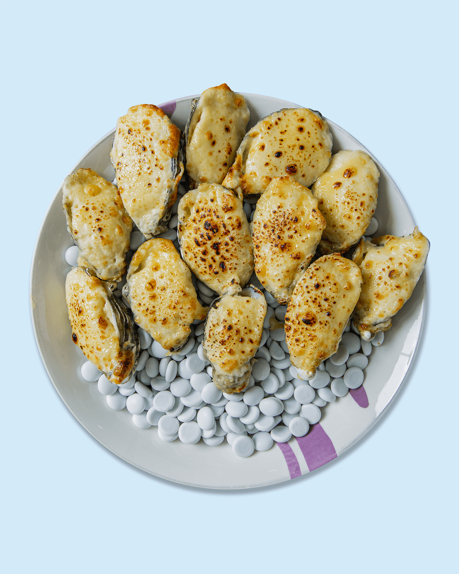 Close-up of baked chicken breasts with melted cheese, grilled to golden brown, served on a white plate.