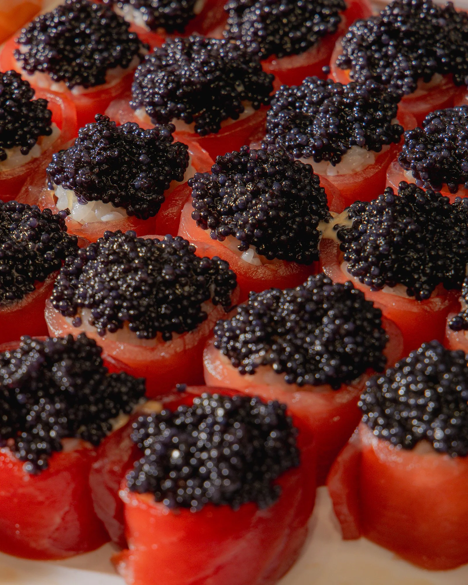 Close-up of sliced tomatoes topped with black caviar.