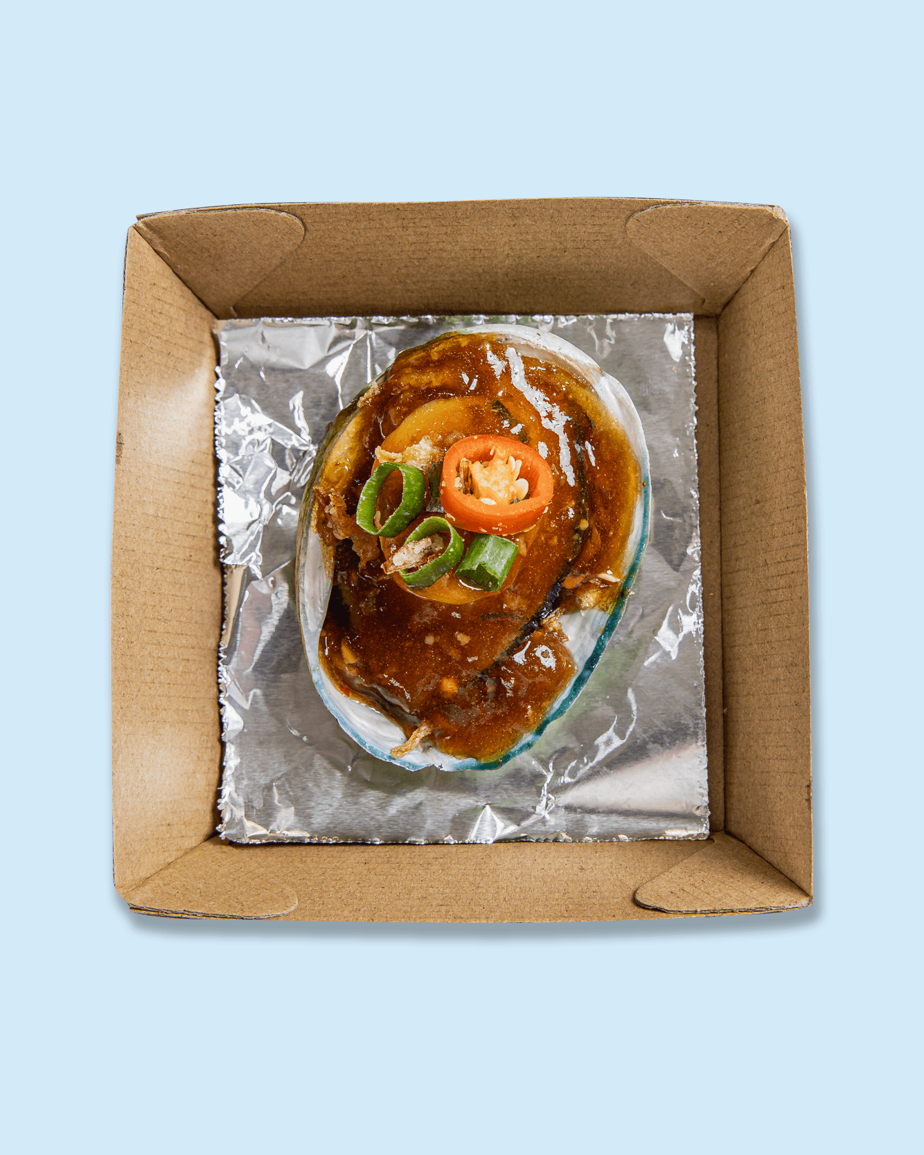 Close-up of baked oysters topped with chopped green onions, sliced red chili peppers, and seasoned bread crumbs.