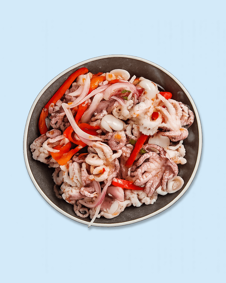 A bowl filled with mixed seafood including octopus tentacles, sliced red bell peppers, and other seafood pieces on white paper with 'Nicholas' branding.