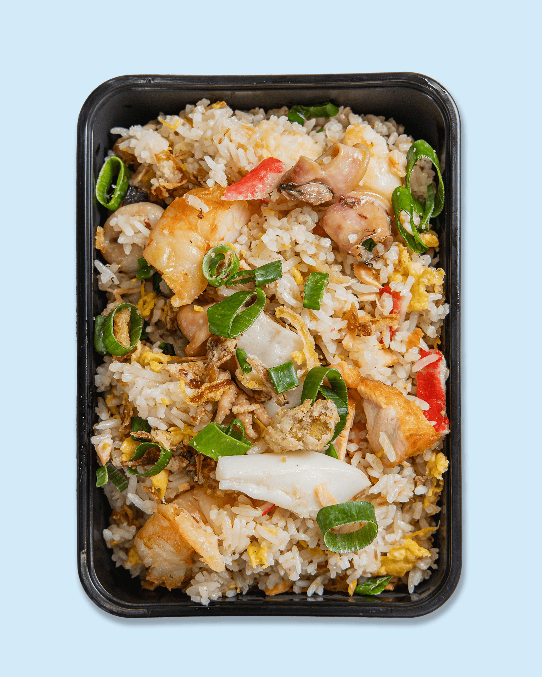 Bento box with rice, shrimp, chicken, eggs, green onions, and vegetables placed on branded paper with 'Nicholas catering & events'.