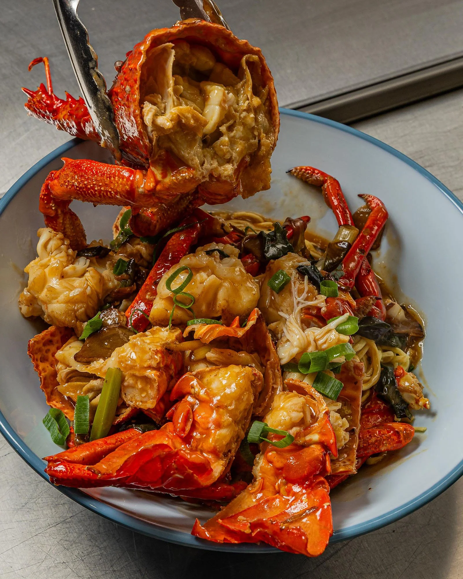 Lobster with stuffing and vegetables served in a white bowl