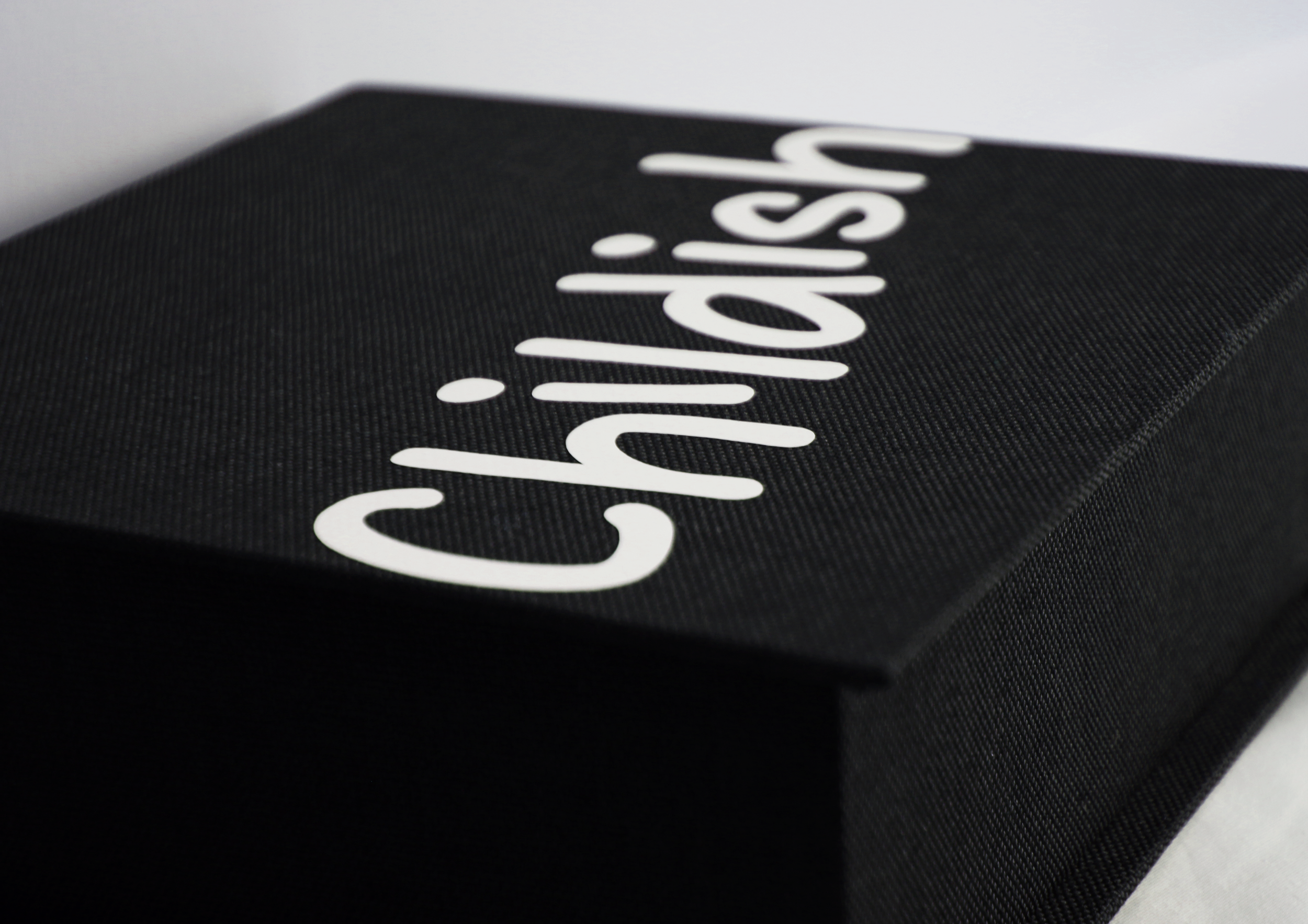 Close-up image of a black box with white text that reads 'Childish' in a stylized font.