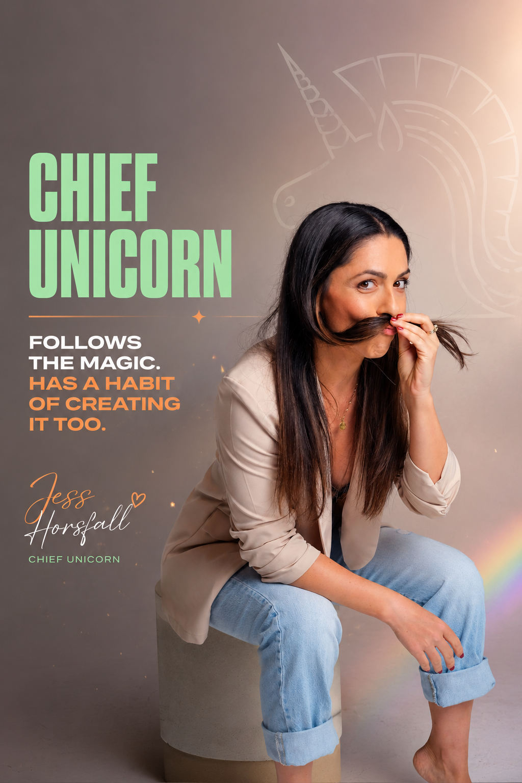 A woman sitting on a stool, holding a strand of her long dark hair to her nose as if to mimic a mustache, smiling playfully. She has light skin, is wearing a beige blazer over a black top, and light blue rolled-up jeans. Behind her is a gray background with a light outline of a unicorn and text about a 'Chief Unicorn' concept.