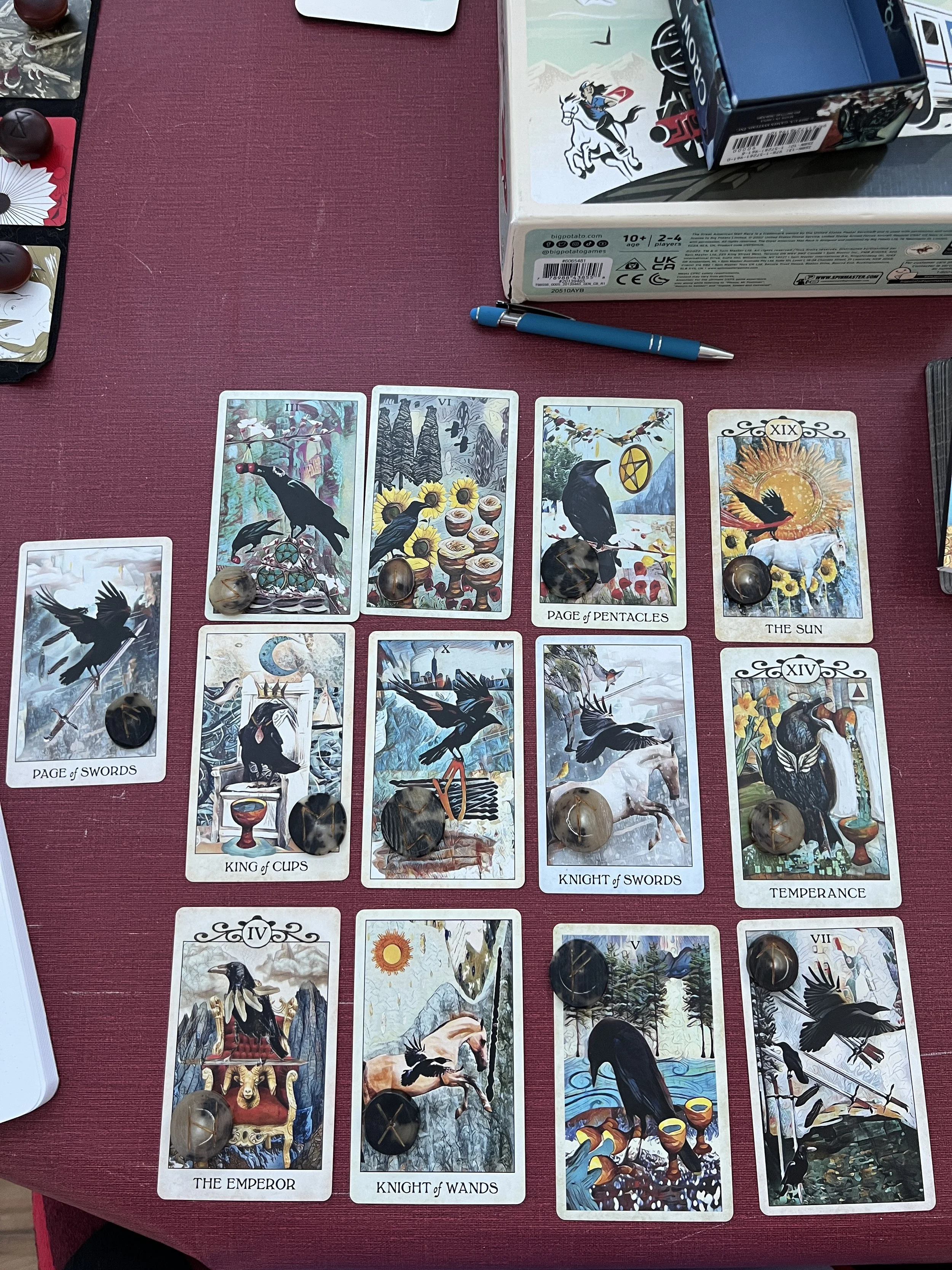 tarot cards laid out in rows of four with a bone rune on the corner of each