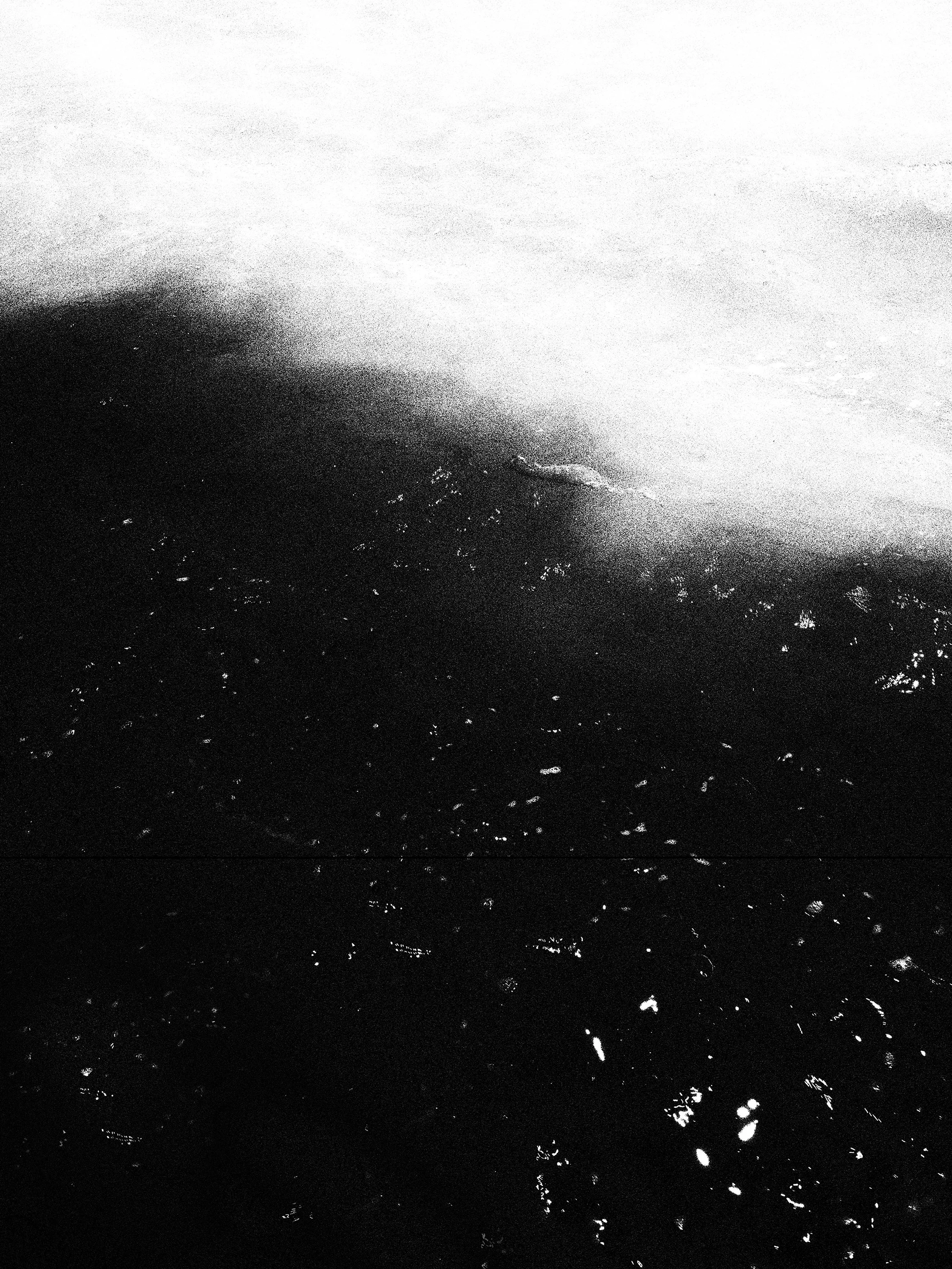 Imagem em preto e branco mostrando uma superfície de água com pequenas ondas e reflexos.