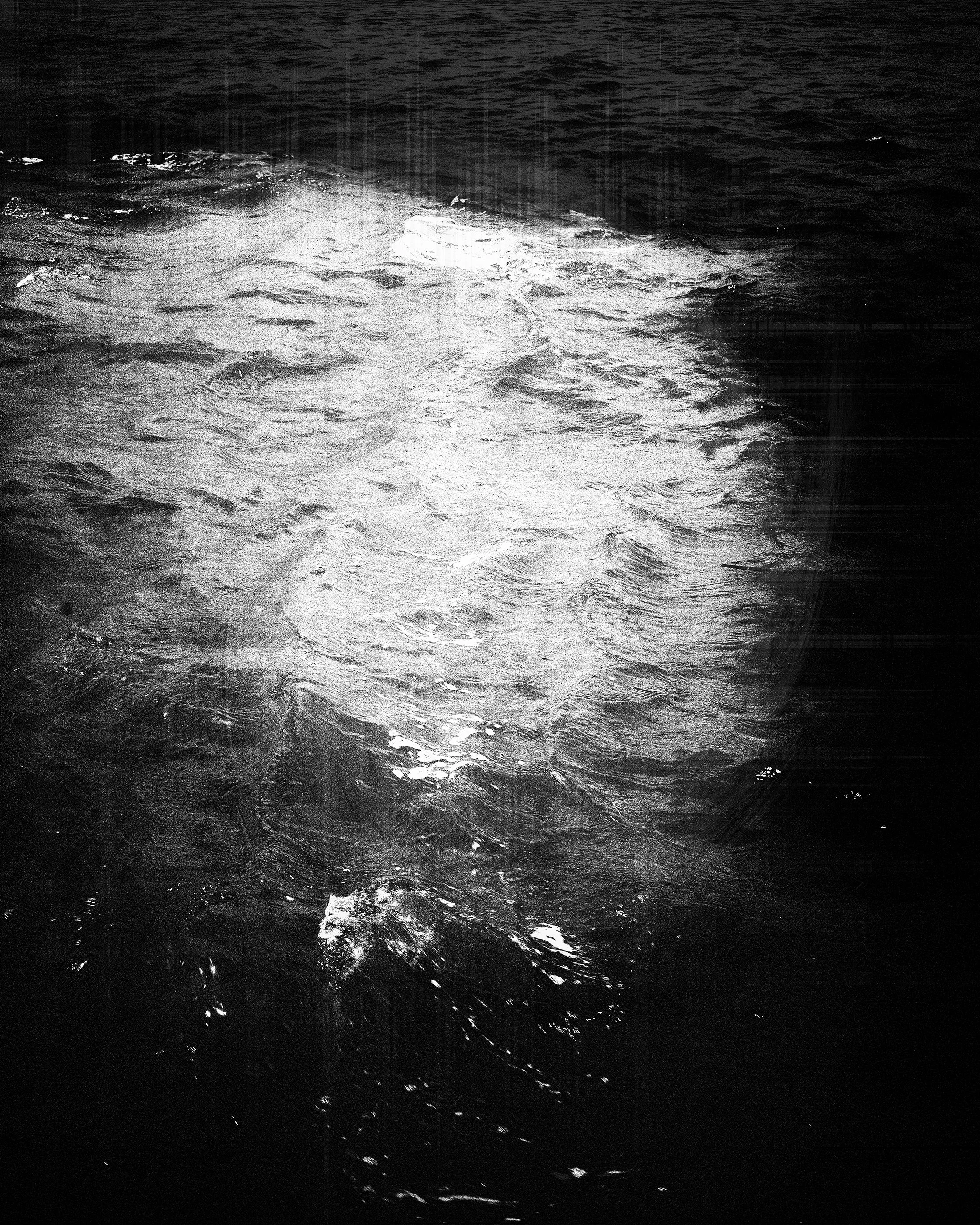 Imagem em preto e branco de ondas na água.