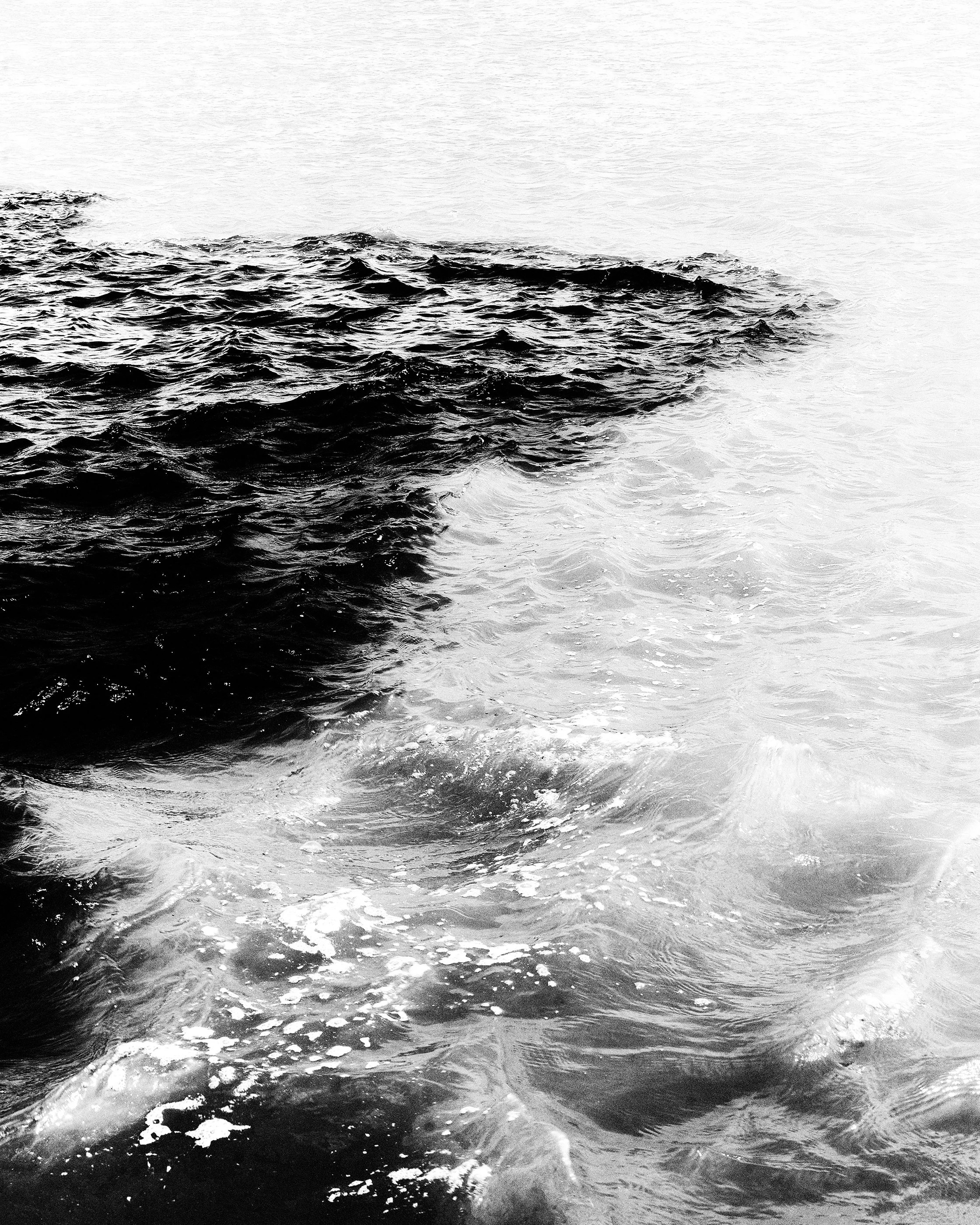 Imagem preta e branca de ondas no mar.