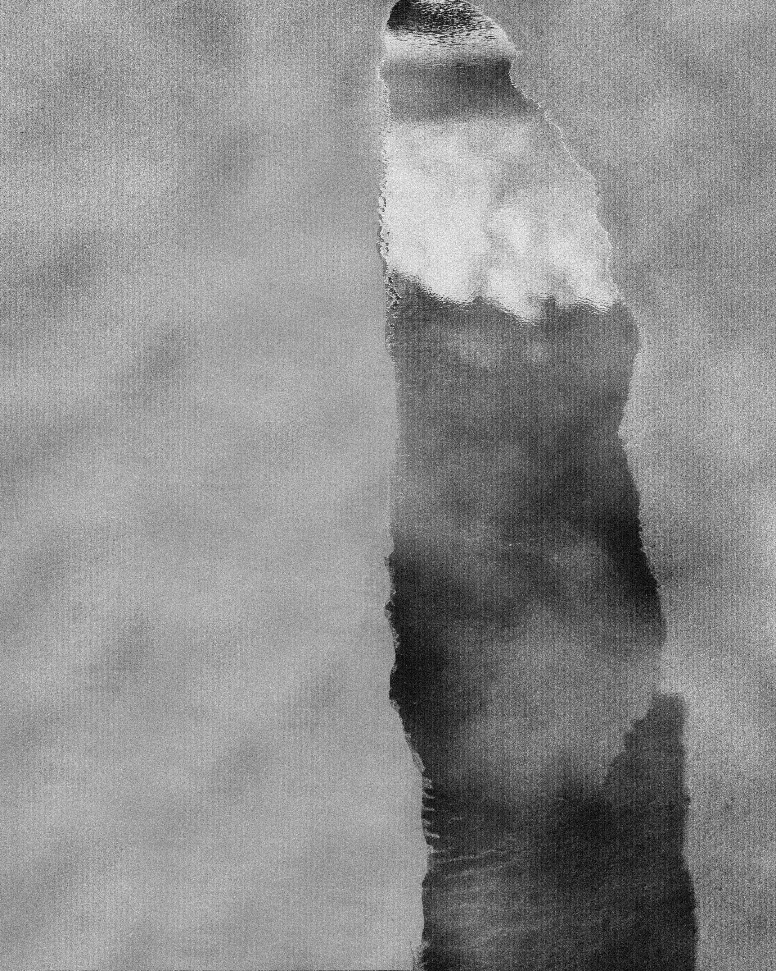 Imagem em tons de cinza de uma formação rochosa na água, vista de cima, refletida na superfície.