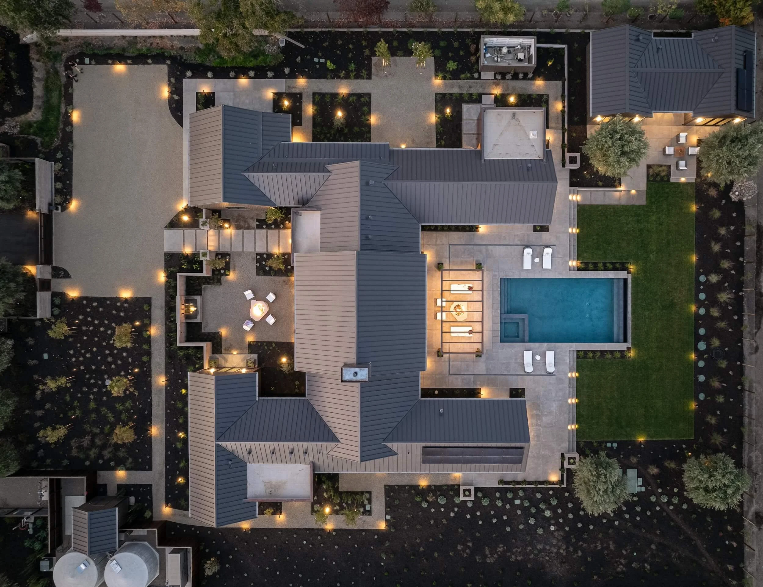 Aerial view of a custom estate showing integrated smart home exterior lighting and synchronized landscape design.