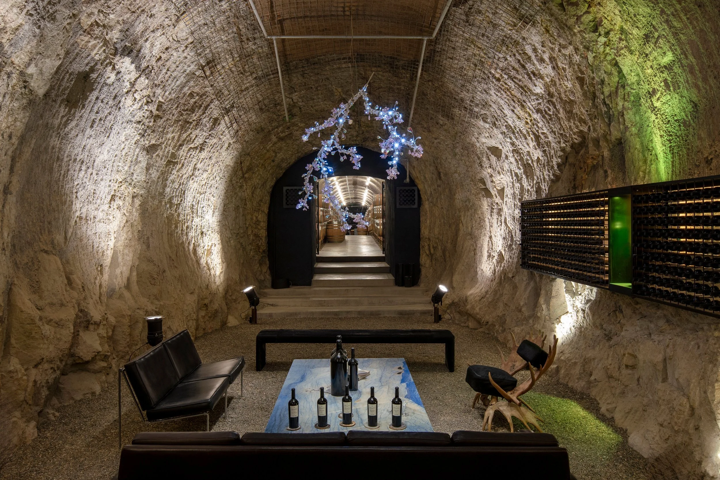 Carefully placed lighting highlights the natural stone walls and intimate gathering space within the Hourglass Winery wine cave.