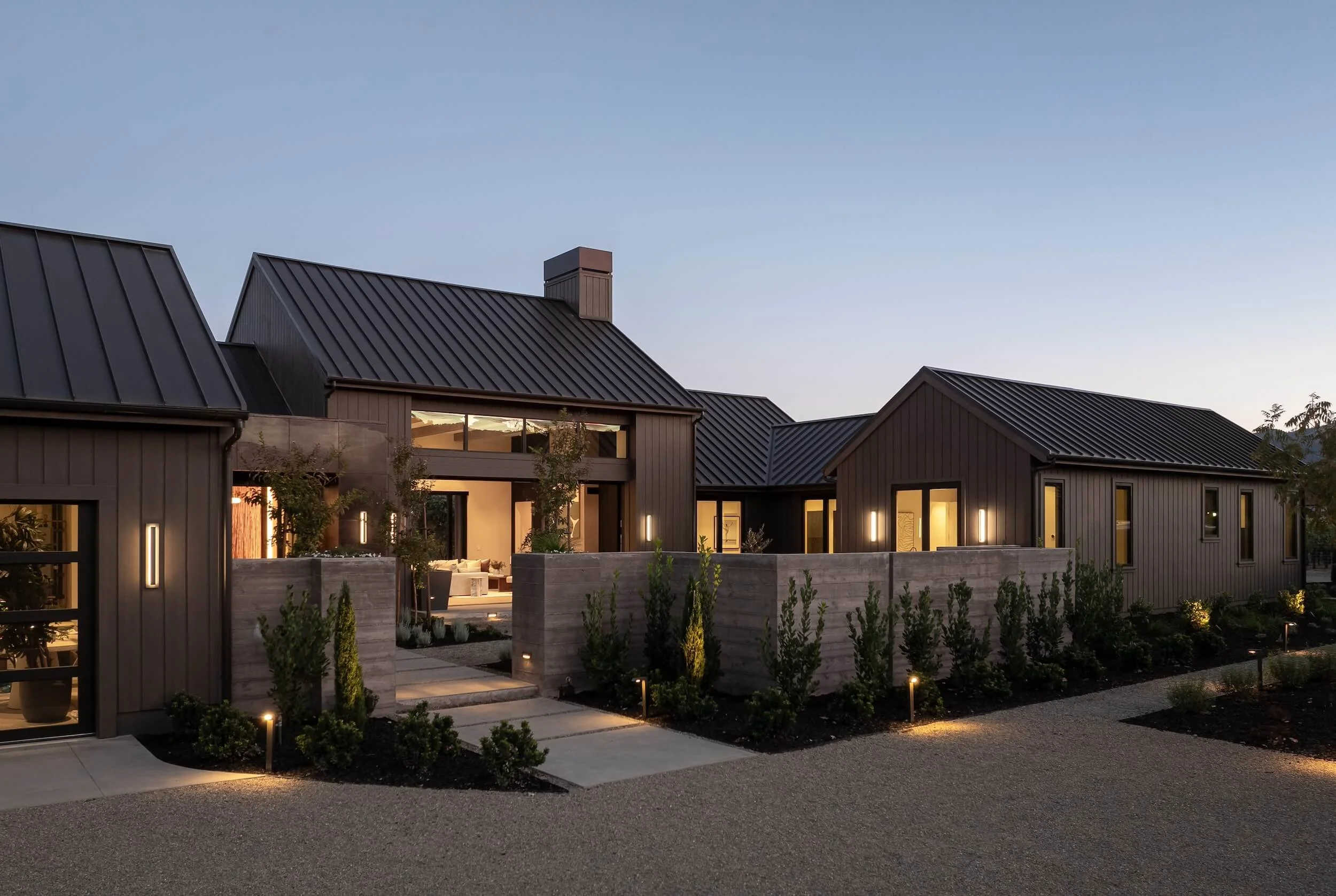 Warm LED wall sconces and pathway lighting accentuating the modern facade of a luxury residence.
