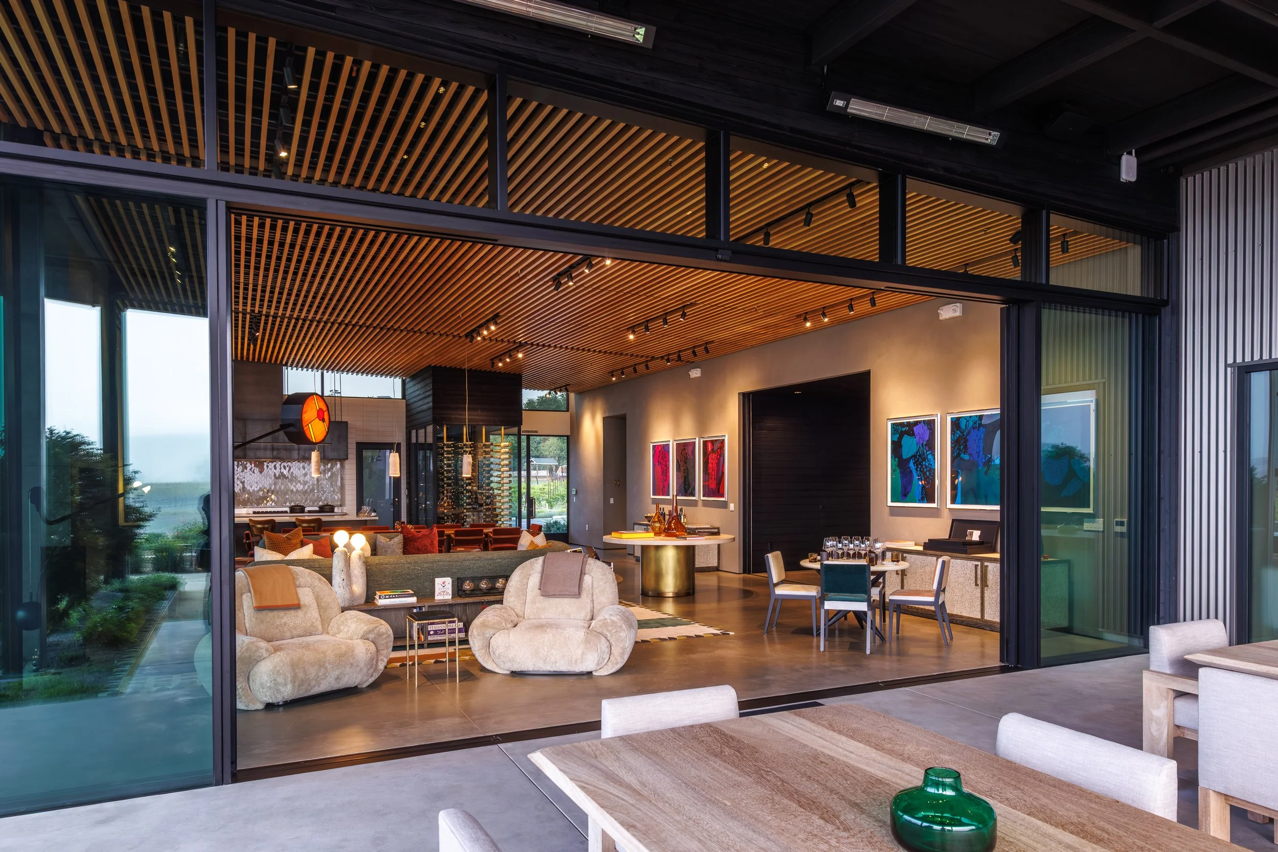 Layered lighting creates a warm hospitality environment while emphasizing the winery's clean architectural lines and connection to the surrounding property.