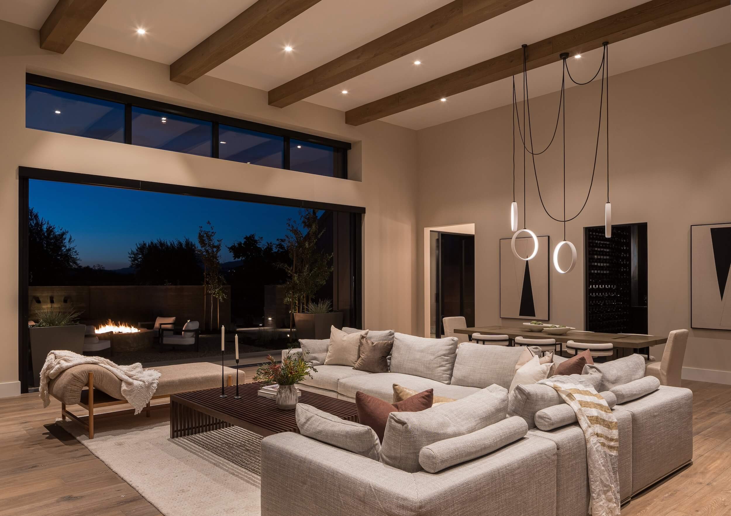 Designer minimalist pendant lights and integrated ceiling spots in a luxury open-concept great room.